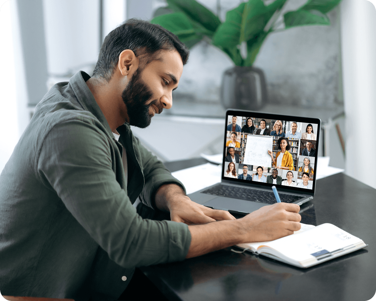 Man writing notes during a video call.