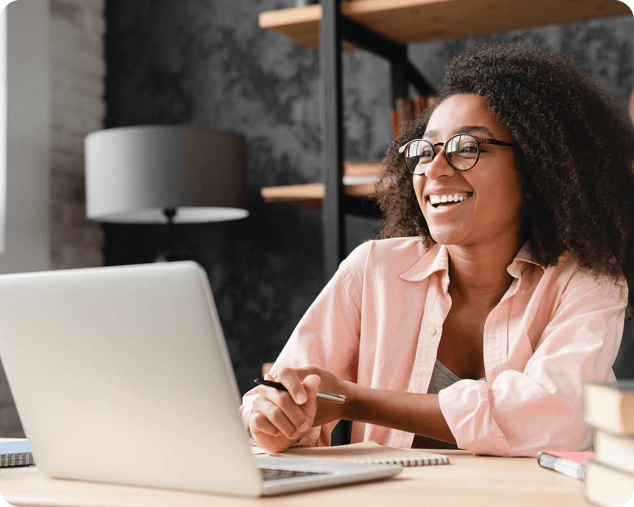 Smiling person working on a laptop.